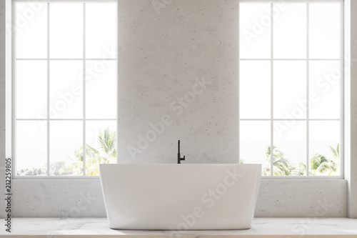 White bathtub in a loft white bathroom interior