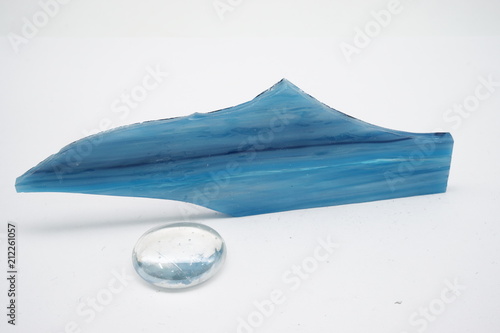 Blue glass piece and glass ball on white