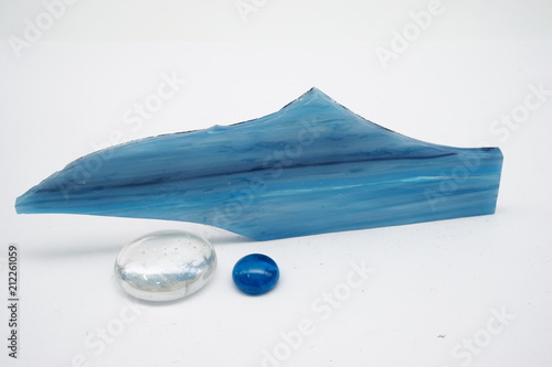 Blue glass piece and glass balls on white