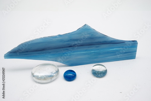Blue glass piece and glass balls on white