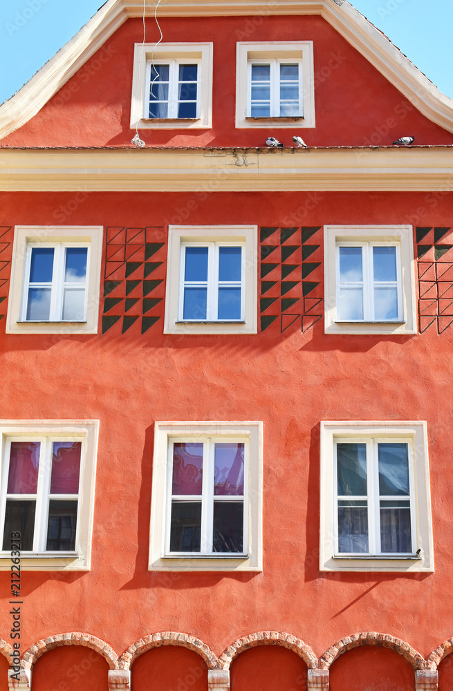 Old town building with bright orange decorative facade in poznan poland.