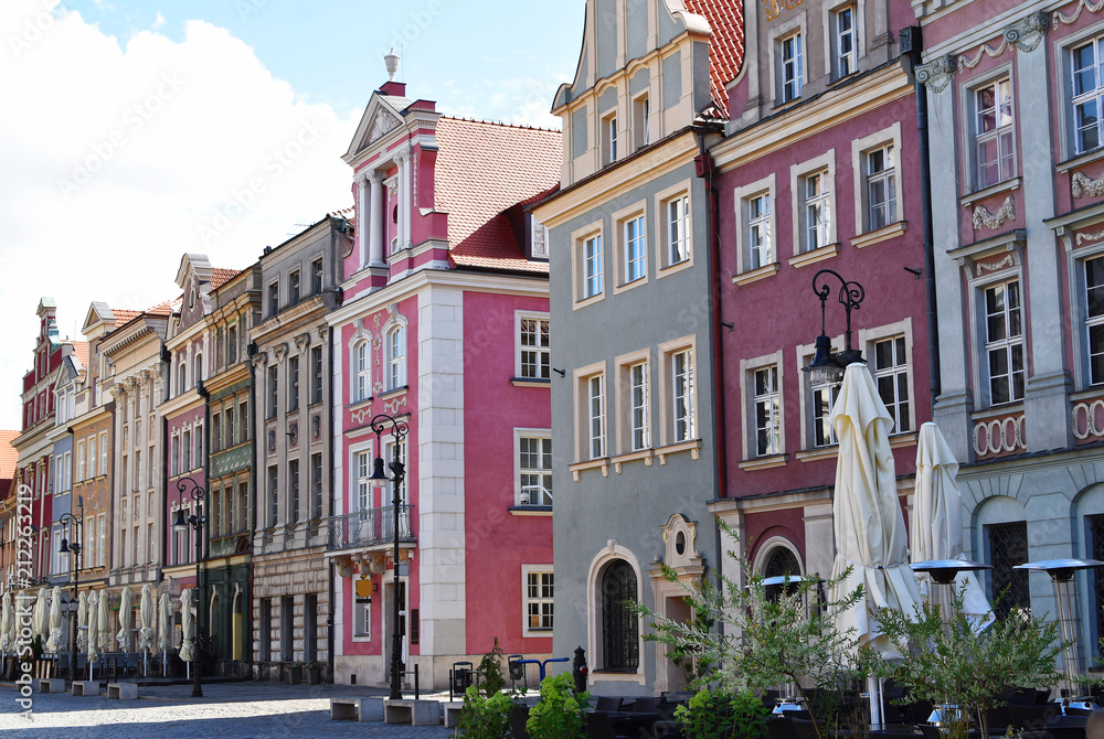 Fototapeta Old town buildings with colorful decorative facade on sky background in summer morning in old market square poznan poland with copy space for text.