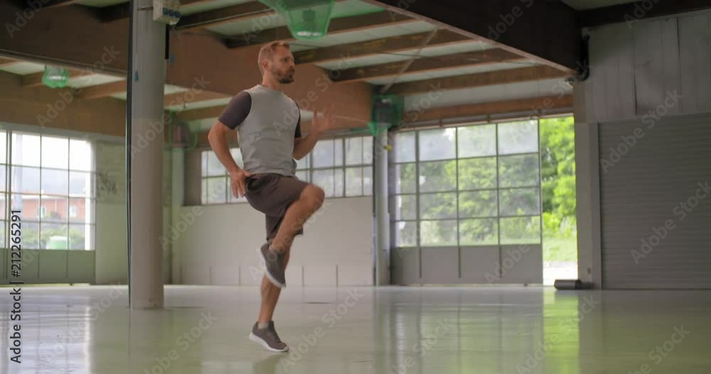 Young adult man doing high knees jumping exercise during fitness sport workout .Grunge industrial urban training.4k slow motion video Young adult man doing high knees jumping exercise during fitness sport workout .Grunge industrial urban training.4k slow motion video