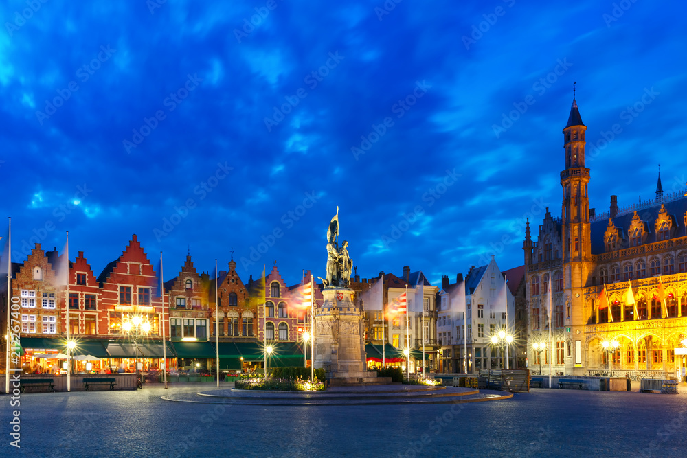 Typical Flemish colored houses and statue of Jan Breydel and Pieter de Coninck on the Grote Markt or Market Square during evening blue hour, Bruges, Belgium