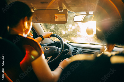 Frau fährt Auto in der Abendsonne photo