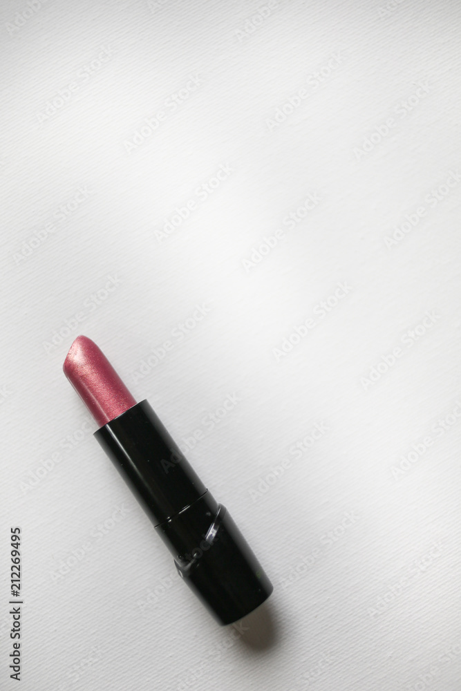 Overhead above view of makeup. Flatlay of pink lipstick with white copy space for fashion or beauty bloggers, salons, or makeup artists.