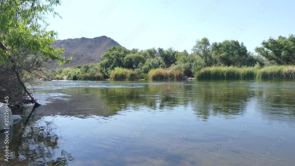 Arizona, Salt River, A view looking upstream on the Salt River with trees and a mountain Arizona, Salt River, A view looking upstream on the Salt River with trees and a mountain