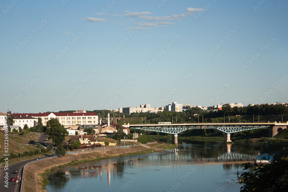 Sights and views of Grodno. Belarus. The Neman River, flowing through the city, buildings along the banks and a bridge across the river.