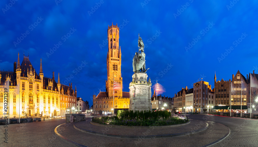 Naklejka premium Wieża Belfort i posąg Jana Breydela i Pietera de Conincka na Grote Markt lub Rynku podczas niebieskiej godziny wieczornej, Brugia, Belgia
