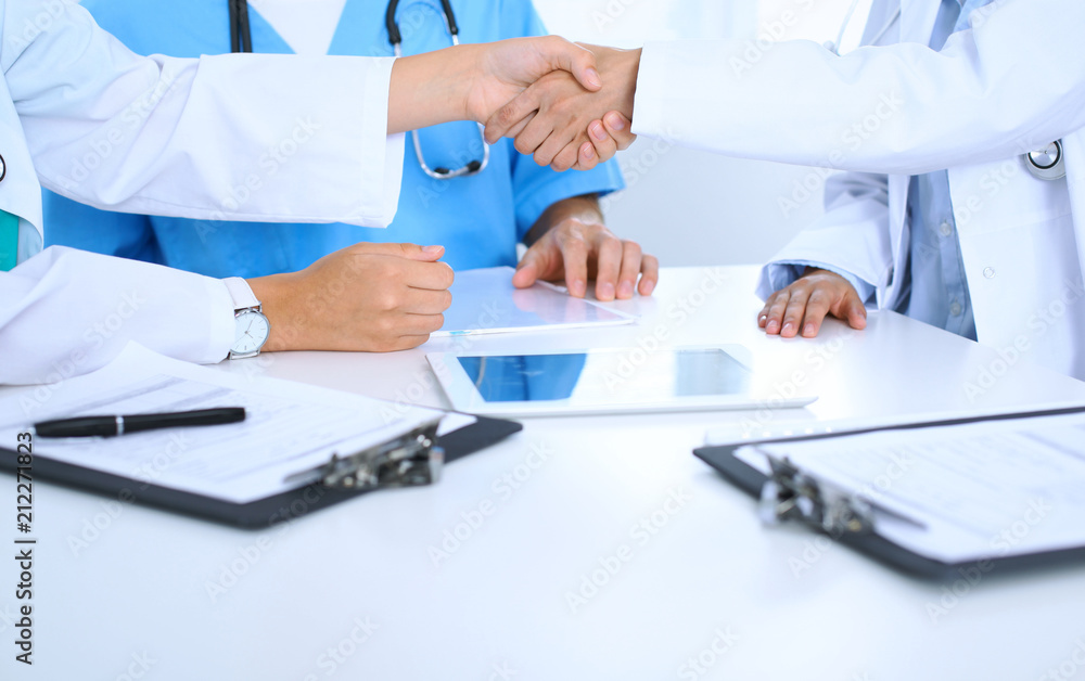 Two doctors shaking hands to each other at meeting. Teamwork and agreement in medicine Two doctors shaking hands to each other at meeting. Teamwork and agreement in medicine