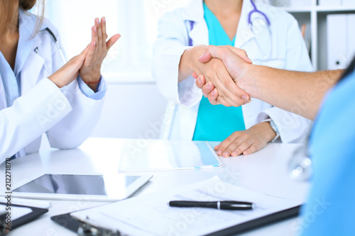 Two doctors shaking hands to each other at meeting. Teamwork and agreement in medicine