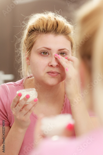 Woman applying face cream with her finger