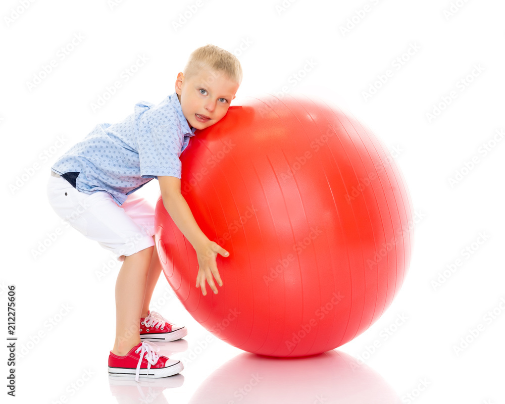 A little boy is playing with a ball. A little boy is playing with a ball.
