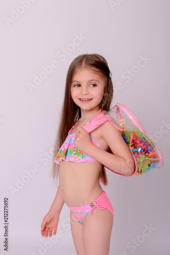  Happy kid with backpack is staying on white background. photo