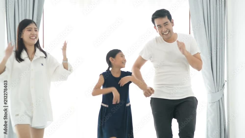 Happy young Asian family dancing together at home. Happy young Asian family dancing together at home.