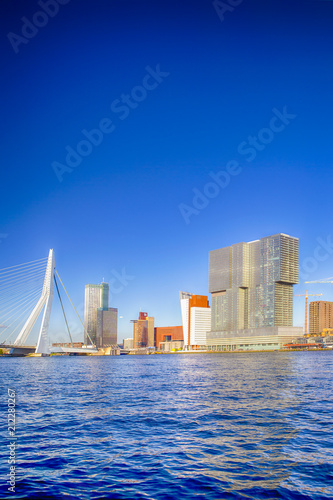 Travel Destinations. Amazing Sunny Cityscape View of Rotterdam Harbour and Port in Front of Erasmusbrug (Swan Bridge) on Background During Daytime. photo