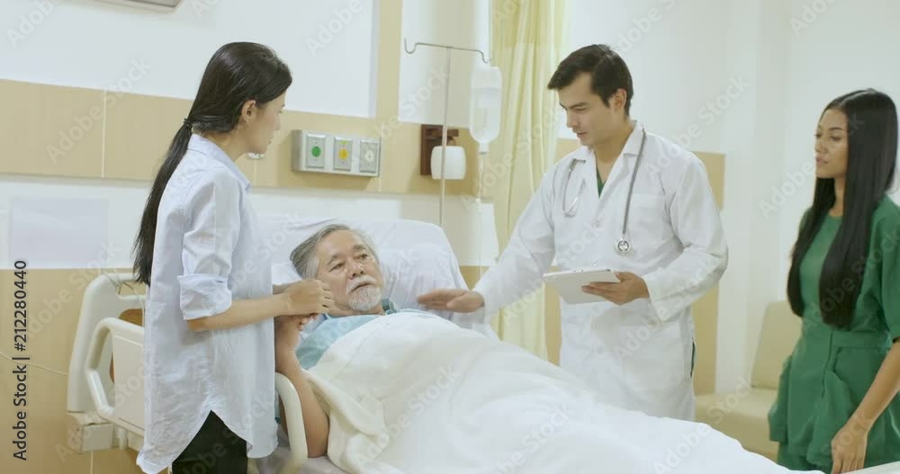 Caring doctor and nurse deliver bad news to a patient bedside Caring doctor and nurse deliver bad news to a patient bedside