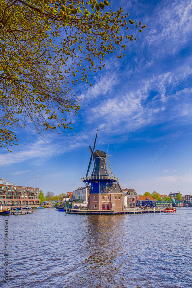 Travel Destinations Concepts. Picturesque View of Harlem Cityscape With De Adriaan Windmill on Spaarne River At  Background During Daytime.