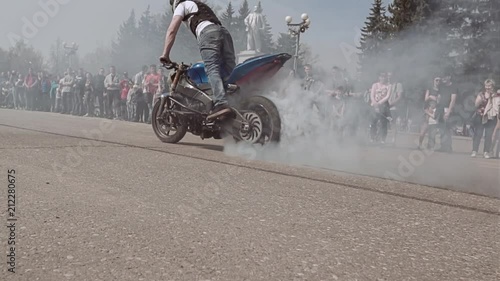 From under the wheels of a sports motorcycle smoke is coming. Mototrial. photo