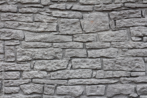 Dark grey stone wall texture made from various large and small stones