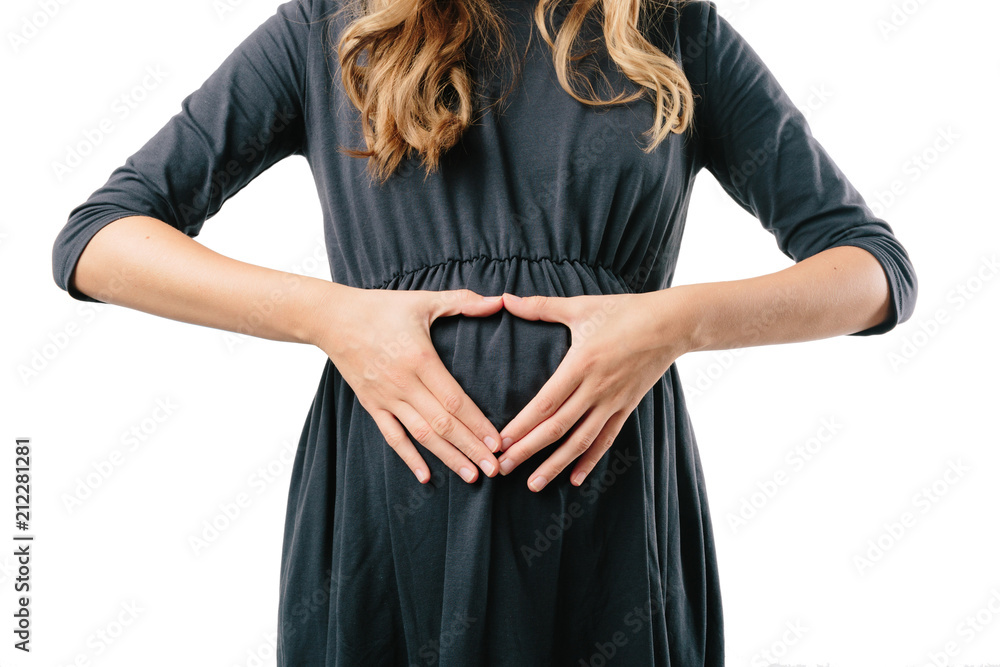 Young pregnant woman in black dress over white background in studio