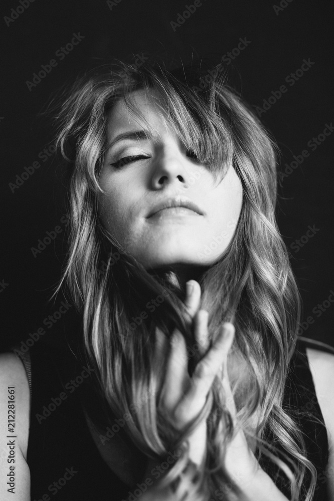 Black and white portrait of a beautiful young woman over black background Black and white portrait of a beautiful young woman over black background