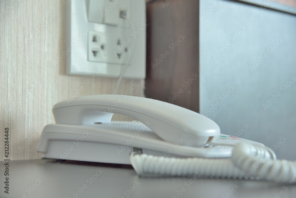 Phone on a table near a plug. Phone on a table near a plug.
