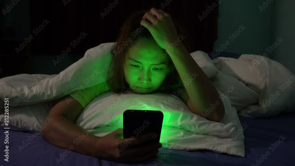 Asian people play smartphone in the bed at night,Thailand people,Addict social media,Play internet all night Asian people play smartphone in the bed at night,Thailand people,Addict social media,Play internet all night