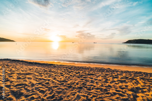 At sunset time on the tropical beach and sea with coconut palm tree