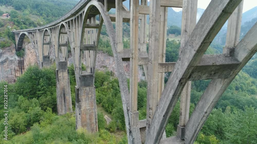 Low angle drone flight past pillars of tall Durdevica Tara bridge, infrastructure in Montenegro Low angle drone flight past pillars of tall Durdevica Tara bridge, infrastructure in Montenegro