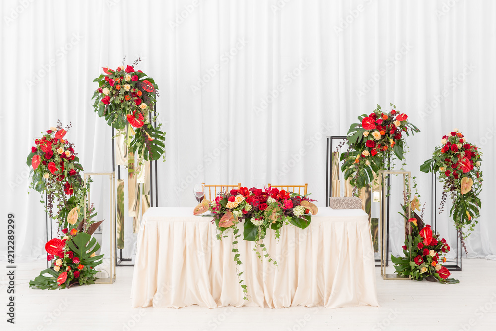 Fototapeta premium Beautiful banquet hall under a tent for a wedding reception. Interior of a wedding tent decoration ready for guests. Decor flowers. Red theme