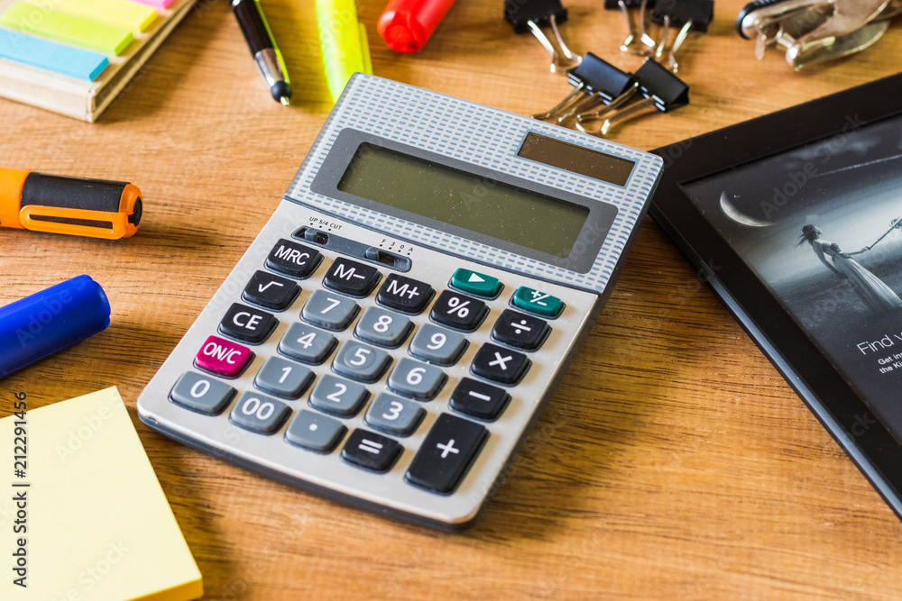 Countant supplies like calculator and markers on a wooden background Countant supplies like calculator and markers on a wooden background