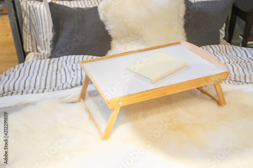 Tray table with book on a bed closeup