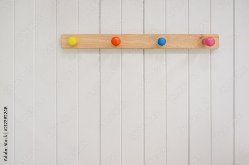 Kids wooden colorful hanger on white wall with copy space Stock Photo | Adobe Stock
