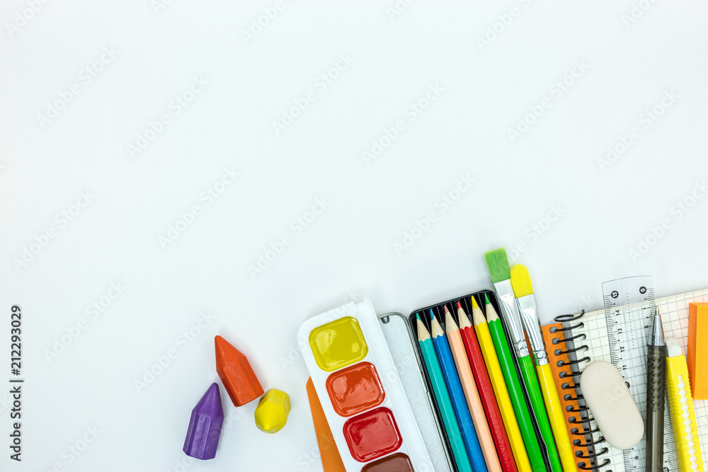 Obraz premium school stationary and tools for kids. notebook, paint, pencils on white desk surface, flat view