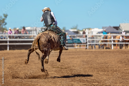 Tableau sur toile Cowboy Riding A Bucking Bull At A Country Rodeo
