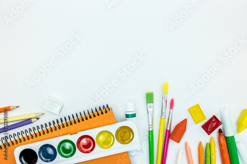 variety of school stationary and tools on white desk background with copy space, flat view
