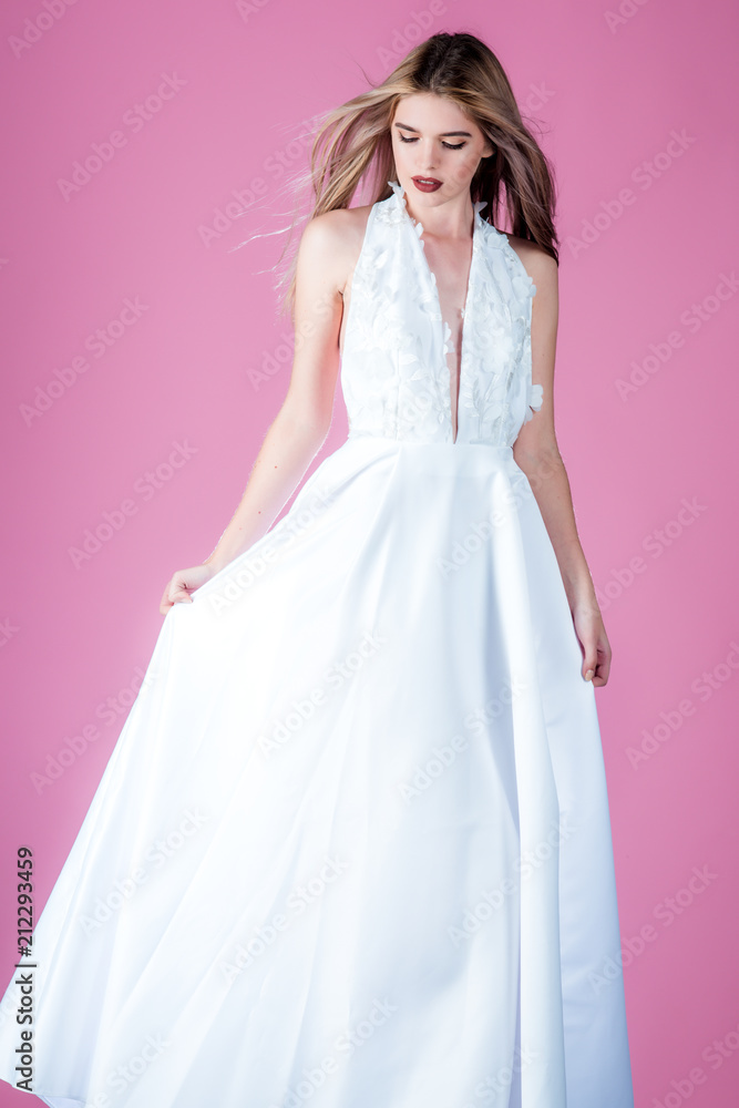 Fashion model or princess at prom. Wedding fashion and beauty salon. Sexy girl in white dress with stylish hair. Woman on pink background in summer dress. Bride girl at wedding ceremony