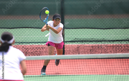 バックハンドを打つ女子ジュニアテニスプレイヤー © DOUBLE BAGEL