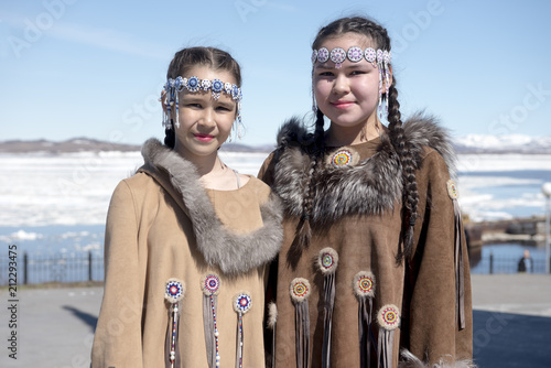 Two chukchi girls in folk dress against the Arctic landscape photo
