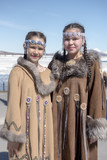 Two chukchi girl in folk dress against the Arctic landscape