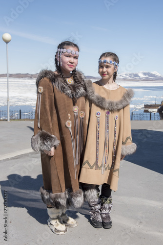 Two chukchi girls in folk dress against the Arctic landscape