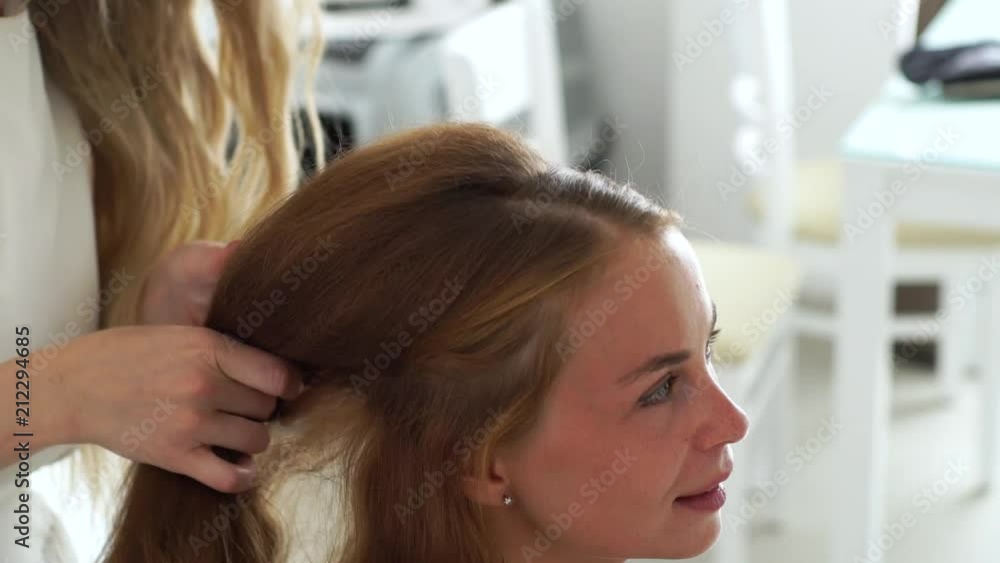 Hairdresser making hairstyle with bouffant and corrugation for young woman with long hair. Hairstylist doing hairdo for longhaired woman in hair dressing salon. Hairdresser making hairstyle with bouffant and corrugation for young woman with long hair. Hairstylist doing hairdo for longhaired woman in hair dressing salon.