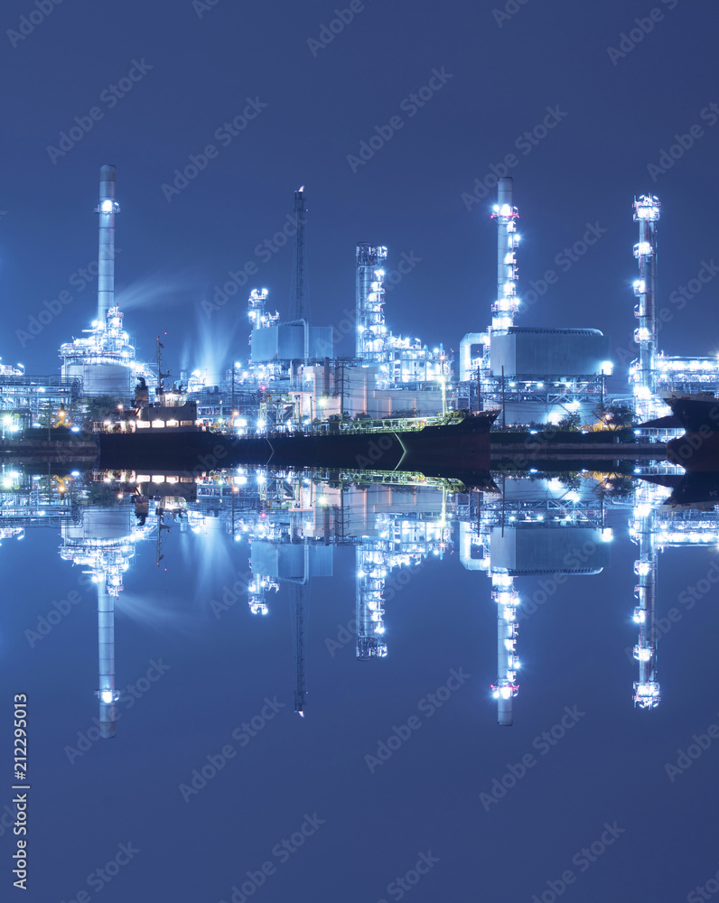 The chemical tanker ship with oil refinery industry port background.