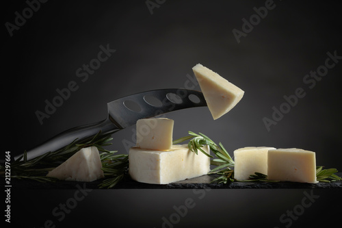 Sheep cheese with rosemary on a black background.