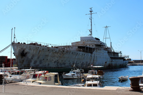Old large historic rusted and beaten down ship called Galeb docked in harbor in Rijeka, Croatia, waiting patiently for restoration and better days while being available for tourists and explorers photo