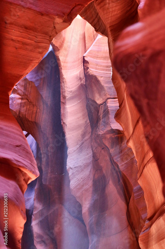Upper Antelope Slot Canyon. Rays of light illuminating red sandstone cave in Upper Antelope Slot Canyon, Page, Arizona, USA. Navajo land. Amazing nature background with falling sand in a light beam.