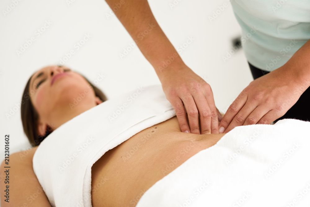 Hands massaging female abdomen.Therapist applying pressure on belly. Hands massaging female abdomen.Therapist applying pressure on belly.