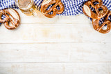 Oktoberfest food menu, bavarian sausages with pretzels, mashed potato, sauerkraut, beer bottle and mug, white wooden background copy space top view