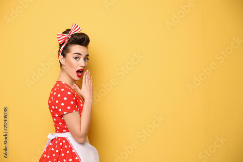 Portrait of funny young housewife on color background